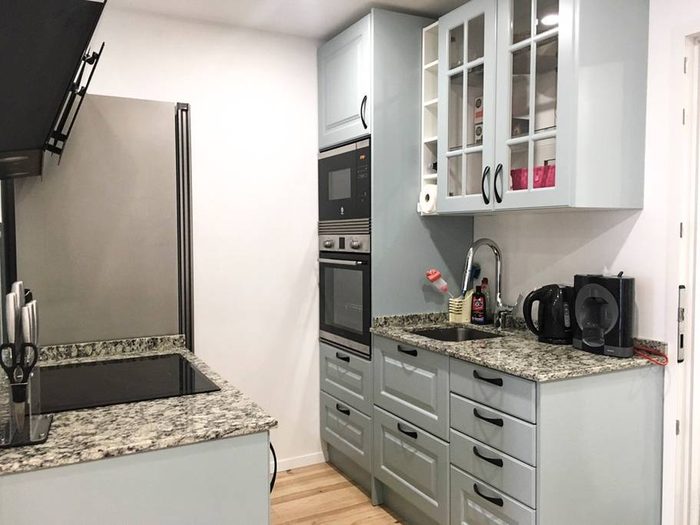 Cuisine avec plan de travail en granit, four et micro-ondes