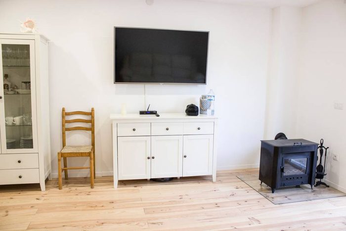 Coin salon avec télévision et poêle à bois